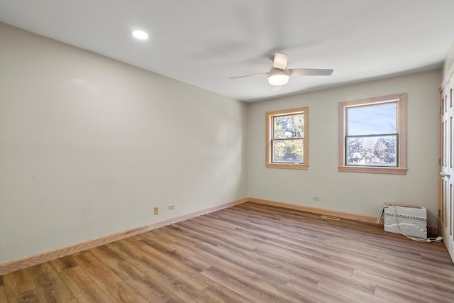 spare room with light wood-style flooring, baseboards, and ceiling fan