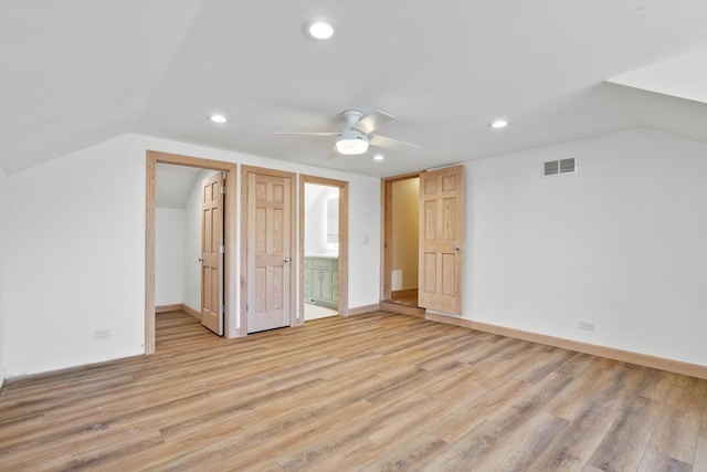 additional living space featuring lofted ceiling, light wood-style flooring, visible vents, and baseboards