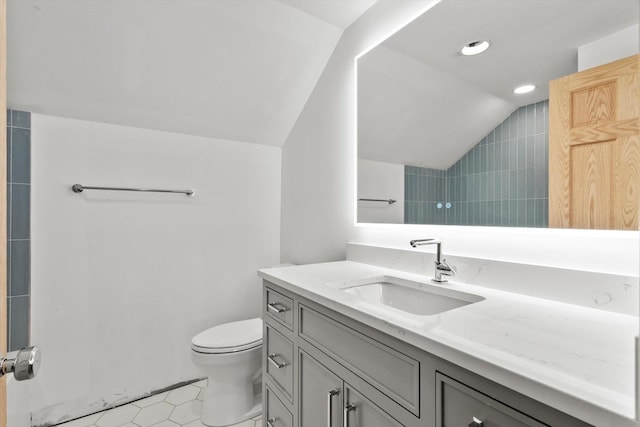 bathroom with lofted ceiling, vanity, toilet, and recessed lighting