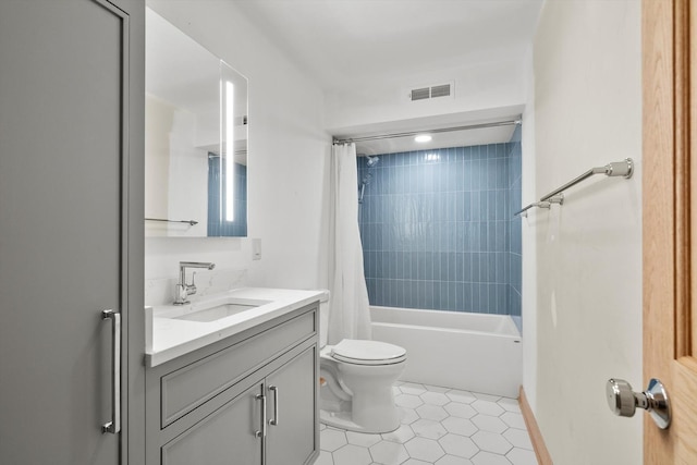 bathroom with toilet, vanity, visible vents, tile patterned floors, and shower / tub combo with curtain