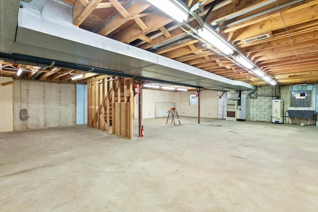 unfinished basement with heating unit, visible vents, and gas water heater