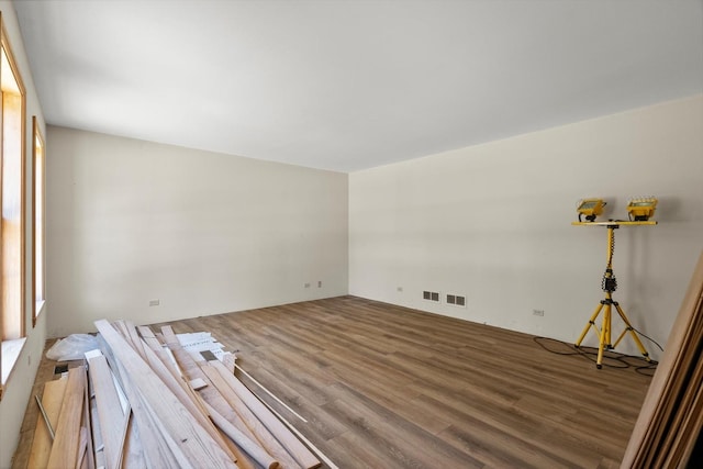 unfurnished room featuring wood finished floors and visible vents