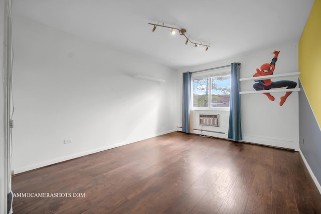 unfurnished room featuring a baseboard radiator, a baseboard heating unit, baseboards, an AC wall unit, and wood-type flooring