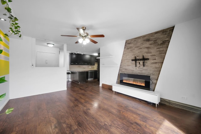 unfurnished living room featuring ceiling fan, dark wood-style flooring, and a fireplace