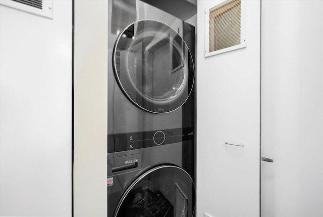 washroom featuring stacked washer / drying machine