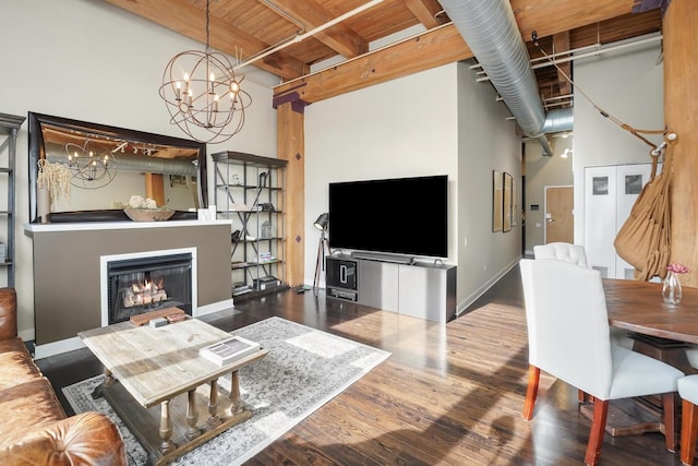 living room with a notable chandelier, wooden ceiling, hardwood / wood-style flooring, a high ceiling, and beam ceiling