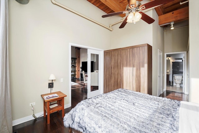 bedroom with a high ceiling, dark wood-type flooring, and ceiling fan