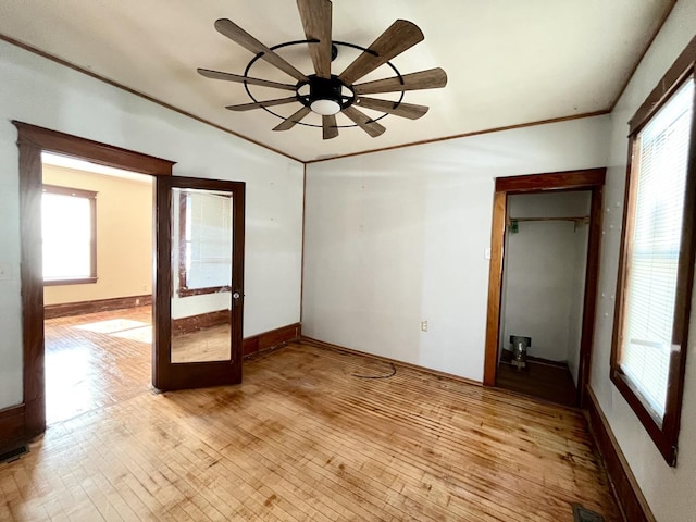 spare room with light wood-style floors, french doors, crown molding, and baseboards