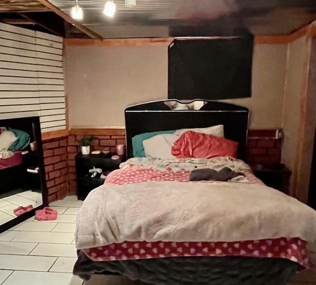 bedroom featuring tile patterned flooring, a wainscoted wall, and a fireplace