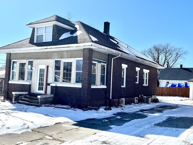 view of front of home featuring brick siding and a chimney