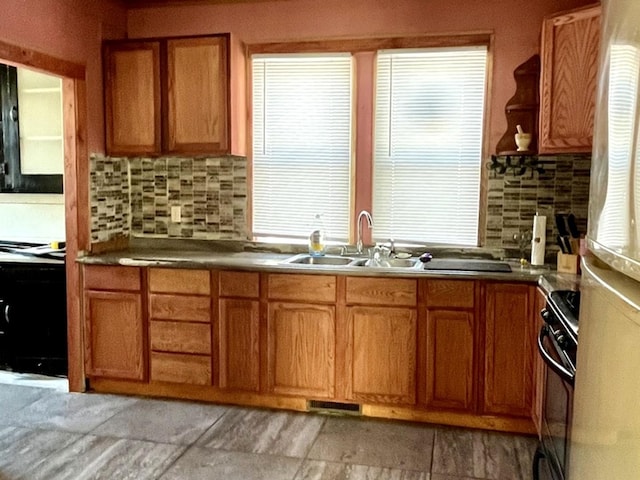 kitchen featuring black range oven, dark countertops, a sink, and brown cabinets