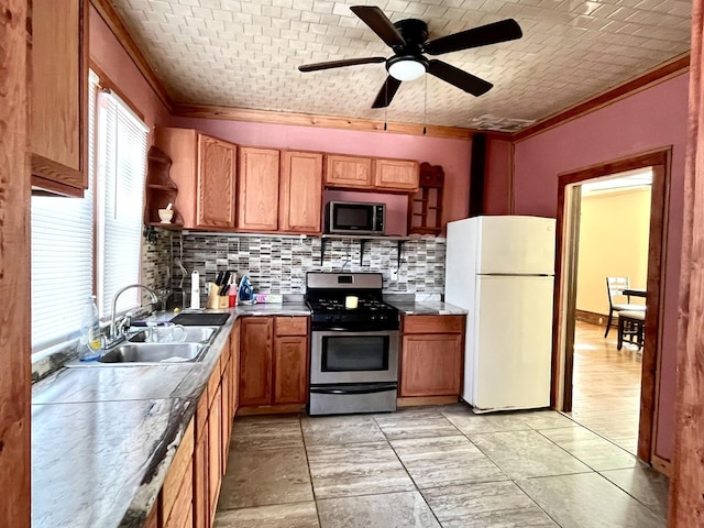 kitchen with a sink, freestanding refrigerator, open shelves, gas range, and crown molding