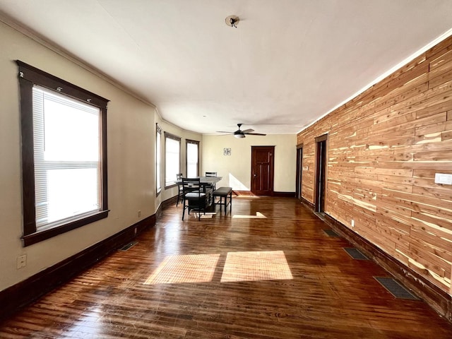 unfurnished dining area featuring baseboards, visible vents, and dark wood-type flooring