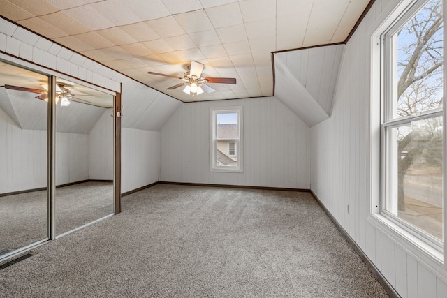 additional living space with lofted ceiling, ceiling fan, carpet, and visible vents