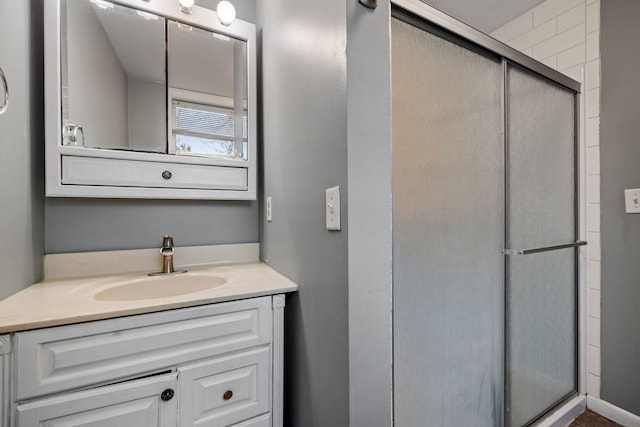 bathroom with a shower stall and vanity