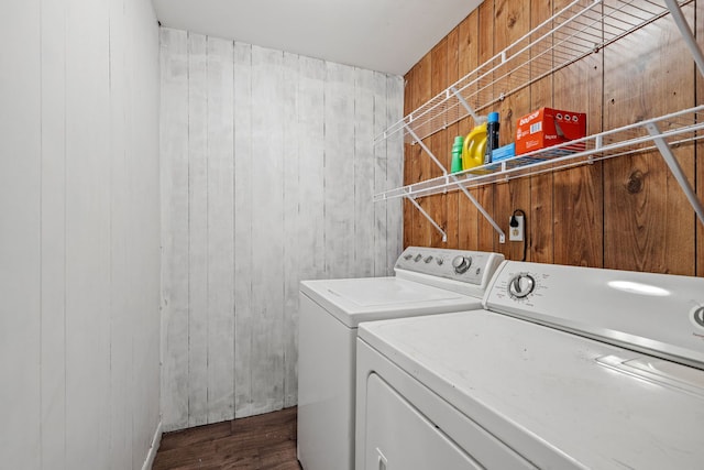 clothes washing area featuring dark wood-type flooring, washing machine and dryer, and laundry area