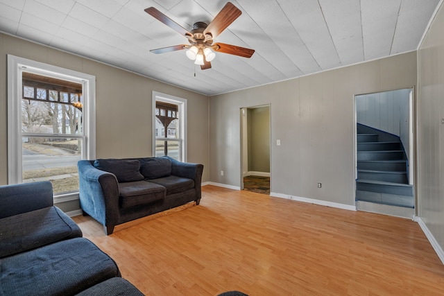 living area with light wood-type flooring, plenty of natural light, and stairs