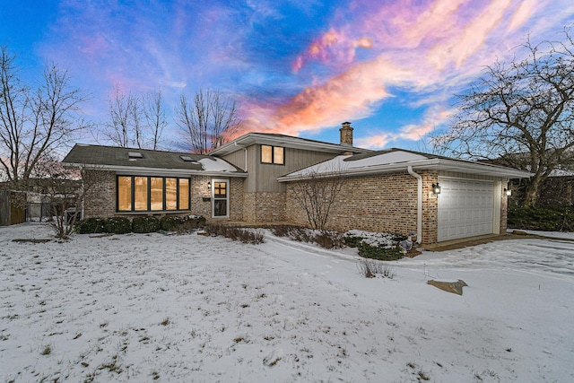 snow covered property with a garage