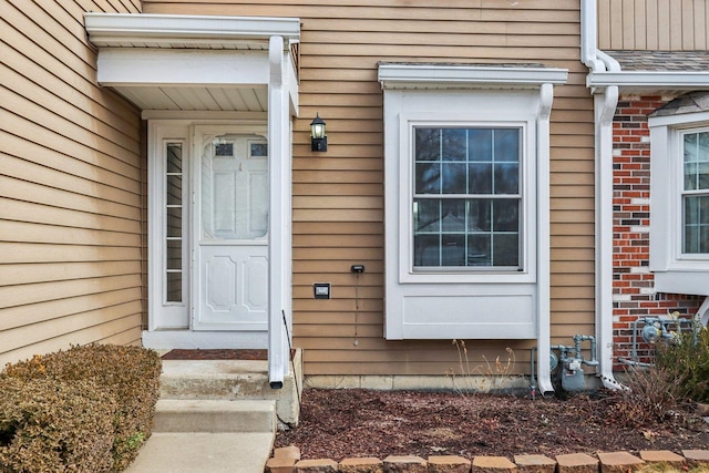 view of exterior entry featuring brick siding