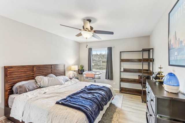 bedroom with light wood-style flooring, baseboards, and ceiling fan