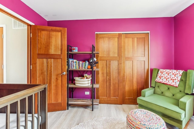 sitting room featuring visible vents and wood finished floors