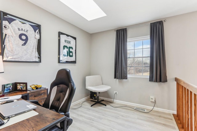 home office featuring baseboards, wood finished floors, visible vents, and a skylight