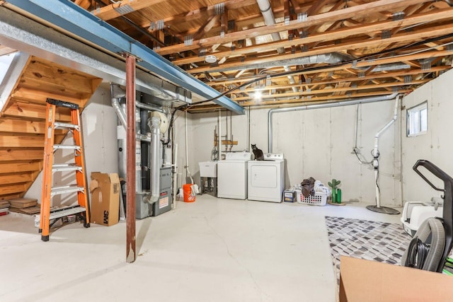 below grade area featuring heating unit and separate washer and dryer