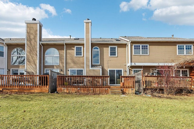 rear view of property featuring a lawn and a deck