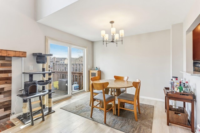 dining room with baseboards, light wood finished floors, and a chandelier