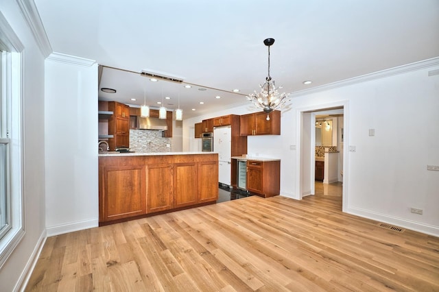 kitchen featuring visible vents, brown cabinets, wall chimney exhaust hood, and light countertops