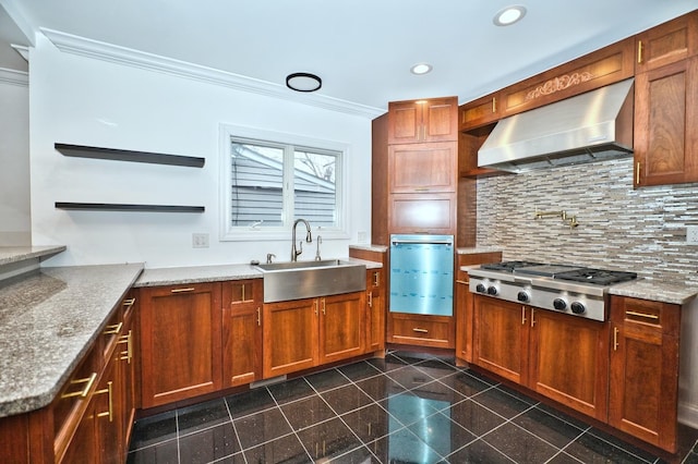 kitchen featuring backsplash, crown molding, stainless steel gas cooktop, exhaust hood, and a sink