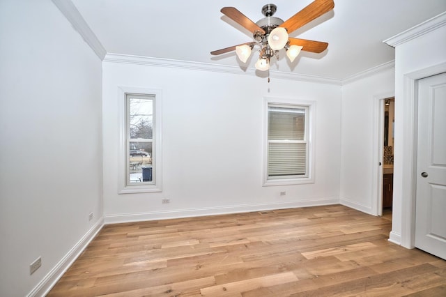 spare room featuring ceiling fan, baseboards, light wood-style flooring, and crown molding