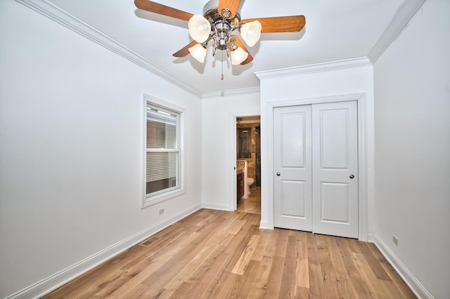 unfurnished bedroom with a closet, baseboards, light wood-style flooring, and crown molding