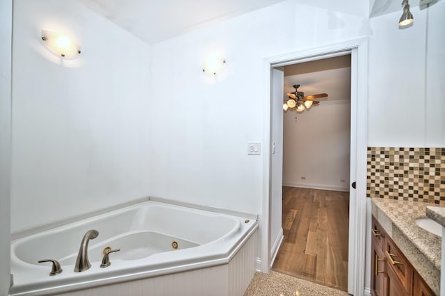 full bath with decorative backsplash, vanity, a whirlpool tub, and a ceiling fan