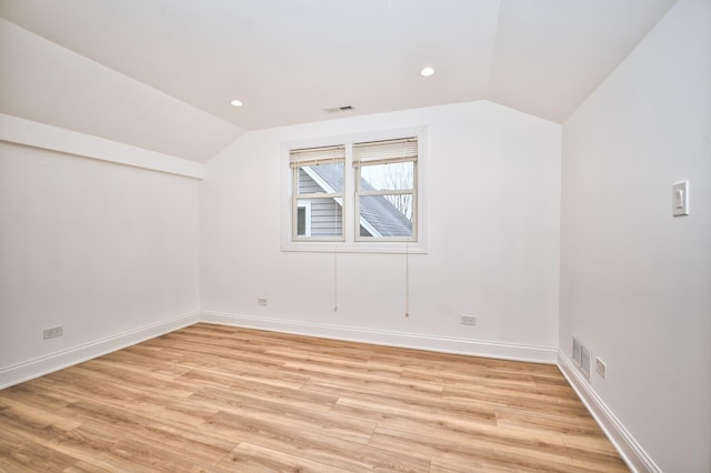 bonus room featuring lofted ceiling, light wood-style flooring, baseboards, and visible vents