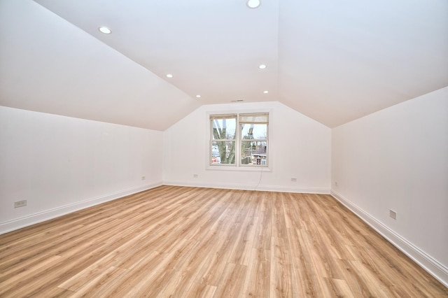 additional living space with lofted ceiling, recessed lighting, baseboards, and light wood-type flooring