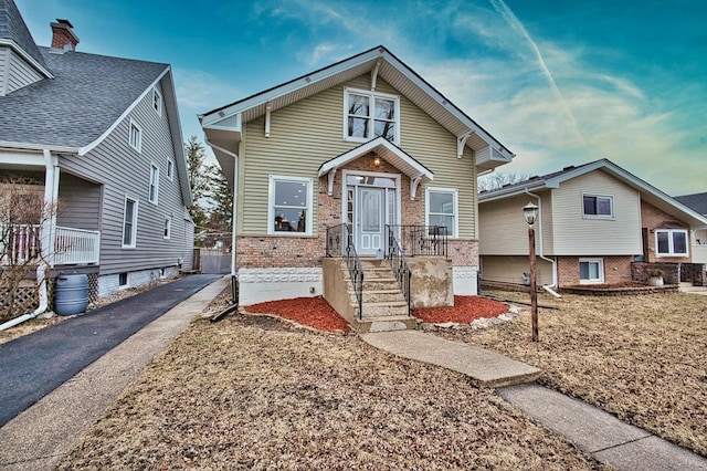 bungalow featuring brick siding