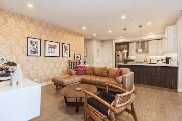 living area featuring baseboards, light wood finished floors, recessed lighting, and wallpapered walls