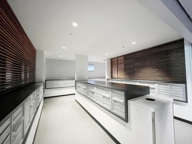 kitchen with a mail area and white cabinetry