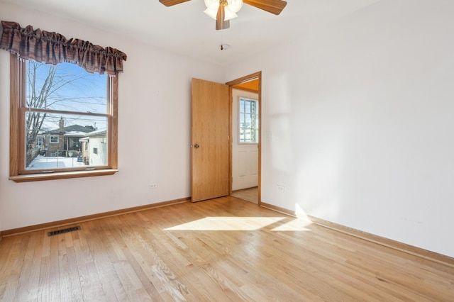 unfurnished room with visible vents, baseboards, light wood-style flooring, and a healthy amount of sunlight