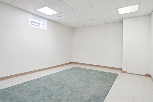 below grade area featuring baseboards and a drop ceiling