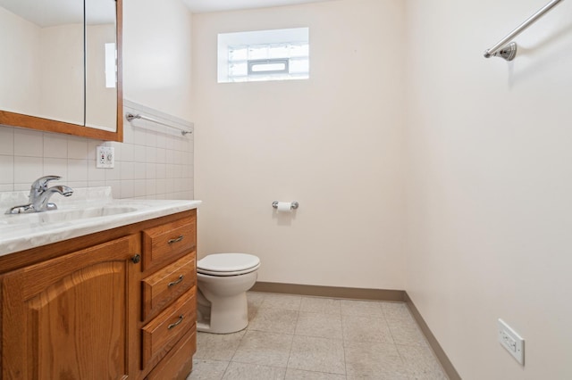 bathroom with decorative backsplash, toilet, vanity, baseboards, and tile patterned floors