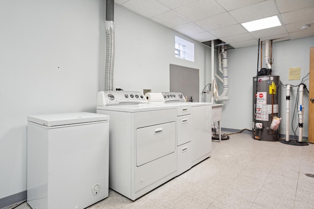 clothes washing area with gas water heater, independent washer and dryer, light floors, and laundry area