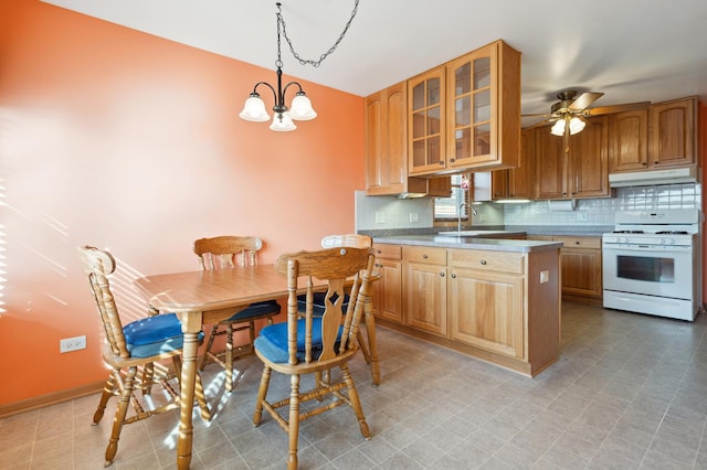 kitchen with decorative light fixtures, glass insert cabinets, white range with gas cooktop, a sink, and under cabinet range hood