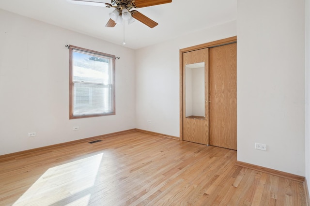 unfurnished bedroom with light wood-style floors, visible vents, ceiling fan, and baseboards