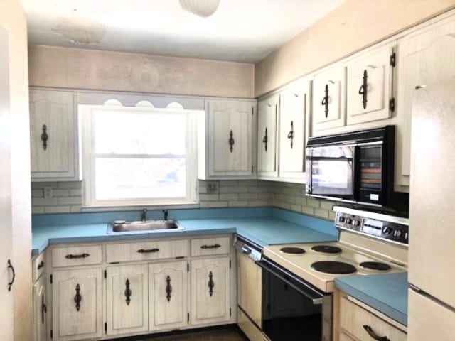 kitchen featuring white appliances, tasteful backsplash, light countertops, and a sink