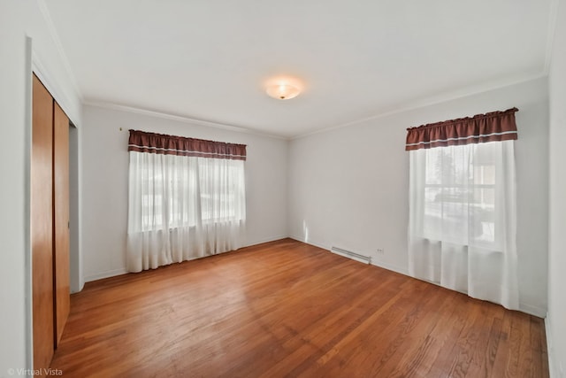 unfurnished room featuring ornamental molding, a wealth of natural light, visible vents, and wood finished floors