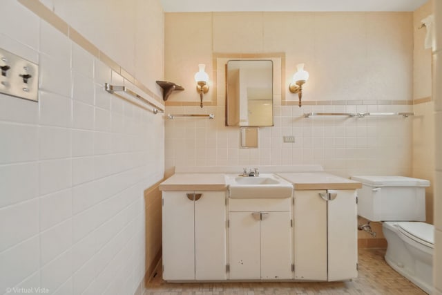 half bathroom with toilet, vanity, and tile walls