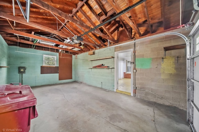 below grade area with a garage and concrete block wall