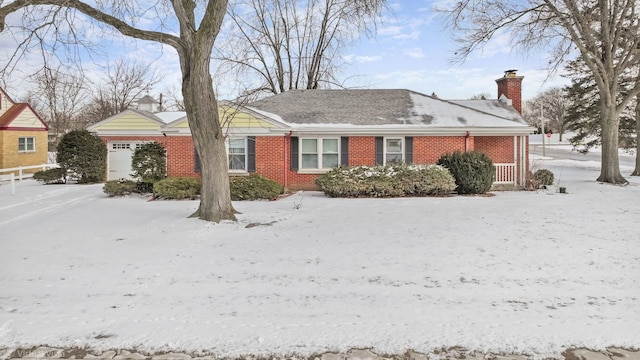 view of front of house with a garage, a chimney, and brick siding